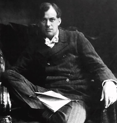 Aleister Crowley as a young man, seated, with papers on his knee